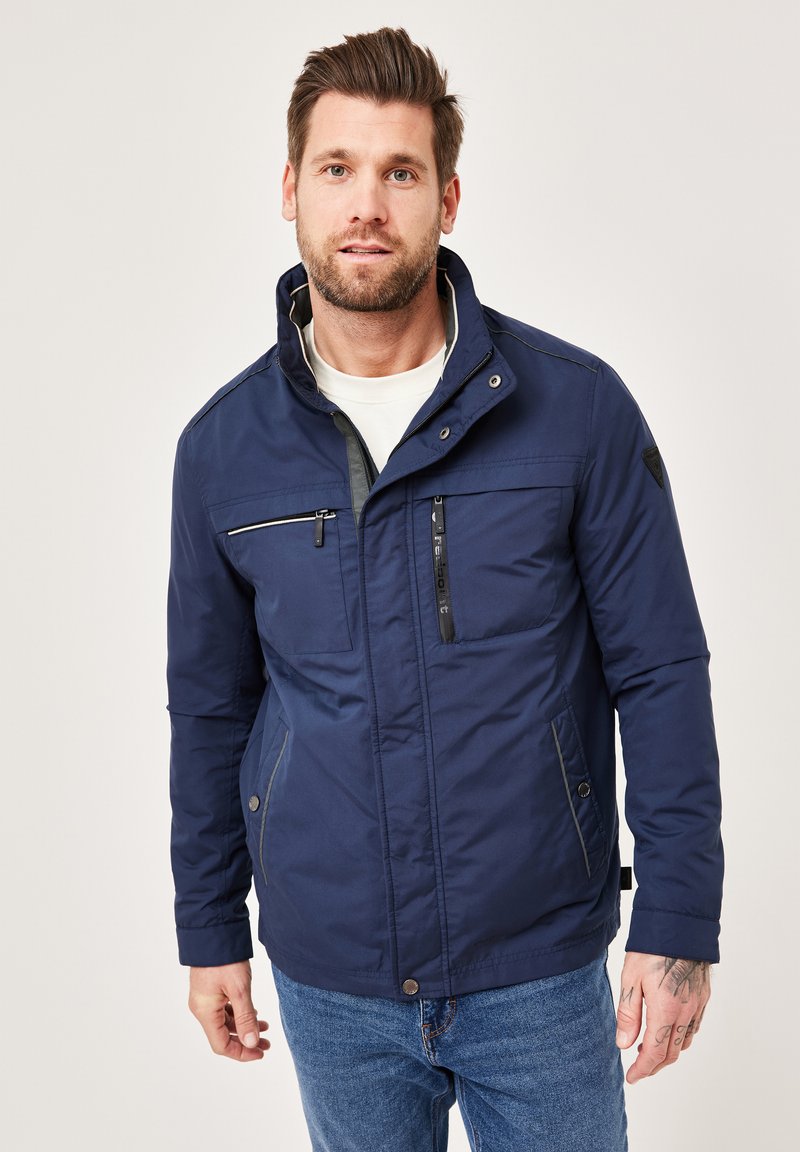 Navy blue jacket with a stand-up collar, zippered chest pocket, and side pockets; features a smooth texture and contrast stitching details.
