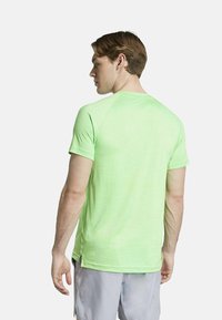 Lichtgroen sportshirt met korte mouwen, een ronde halslijn en subtiele streeptekstuur, met zijsplitten voor mobiel gebruik.