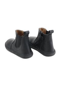 Botas de tobillo de cuero negro con laterales elásticos y cremallera, puntera redondeada, suela de goma texturizada y tiradores para ponerlas y quitarlas fácilmente.