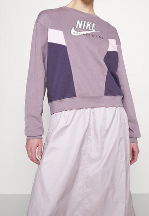 Sudadera Nike morada con diseño en bloques de color en rosa claro y púrpura oscuro, con un cuello redondo y logo en el pecho.