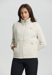 Ljusbeige zip-up väst med en strukturerad fleeceövre och en slät nedre del. Har en hög krage och två sidofickor.