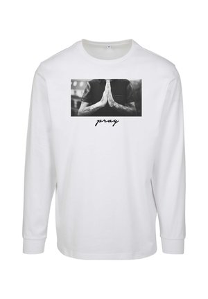 Langærmet hvid T-shirt med et sort-hvidt foto af hænder i bønneposition, med ordet "bede" trykket under i sort.