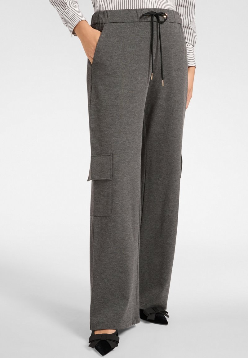 Grijze joggingbroek met een relaxed fit, voorzien van een trekkoord in de taille, zijzakken en cargozakken op de bovenbenen. Zacht geweven stof.
