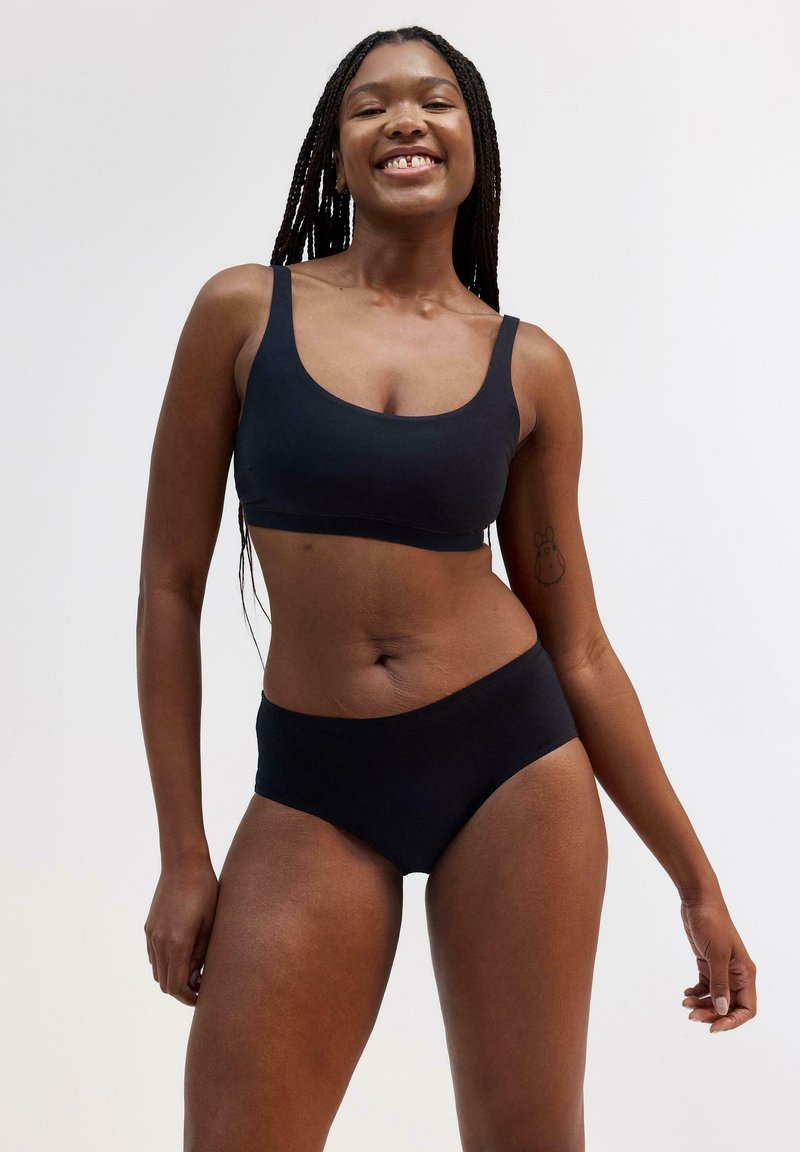 Sort sømløs bralette og høj talje undertøjssæt, lavet af blødt stof. Har en rund halsudskæring og komfortable, brede stropper.