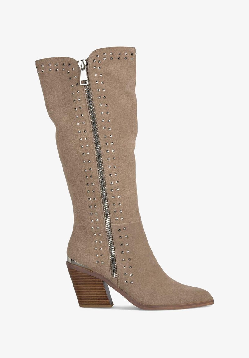 Bota de ante color beige hasta la rodilla con punta afilada, cremallera plateada y acentos de tachuelas a lo largo de la cremallera y el tubo superior. Tacón de madera grueso.