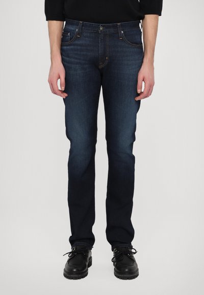 Dunkelblaue Jeans im Slim Fit-Stil mit fünf Taschen, Kontrastnähten und einem Knopfverschluss. Material: Baumwollmischung.