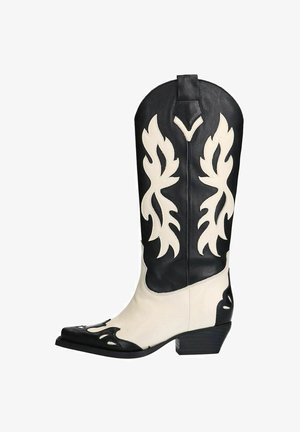 Botte de cowboy en cuir noir et blanc avec des motifs de flammes, bout pointu et talon empilé. Présente des textures de cuir contrastantes.