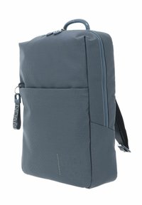 Sac à dos gris avec une surface texturée, doté d'une poche zippée à l'avant, de bretelles rembourrées et d'une poignée supérieure pour un transport pratique.