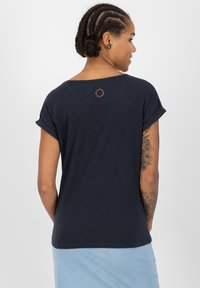 T-shirt navy blu a maniche corte con scollatura rotonda, maniche arrotolate e un piccolo logo circolare sulla parte alta della schiena, con una texture morbida.