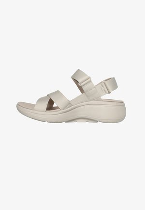 Sandalias con tira ajustable en color beige y plantilla acolchada, con amplias tiras cruzadas y una tira trasera para mayor estabilidad. Diseño ligero.