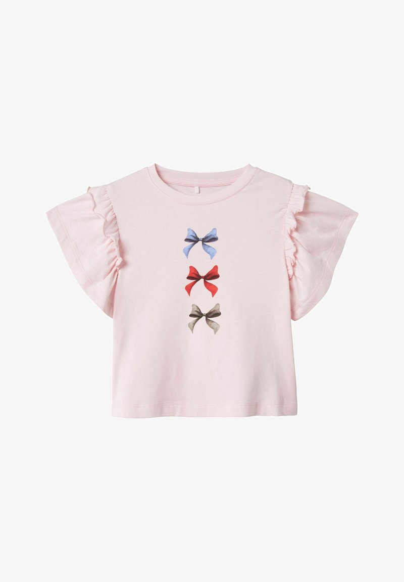 Rožinė medvilninė marškinė su trumpomis volanėlėmis, išsiskirianti trimis spausdintais kaspinais mėlyna, raudona ir pilka spalvomis, išdėstytais vertikaliai priekyje.