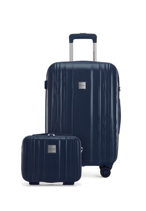 Maleta rígida de color azul marino con textura, asa extensible y bolsa de mano pequeña a juego, ambas con placas con el logo de la marca.