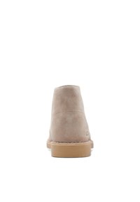 Beiga mockaskängor med en slät yta, rundad topp och gummisula. Baksidan har en minimalistisk design utan dekorationer.