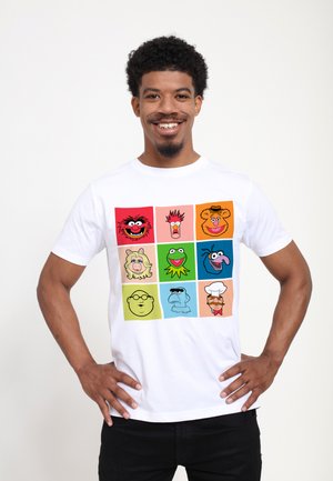 Weißes T-Shirt mit einem Raster aus cartoonartigen Charaktergesichtern in leuchtenden Farben. Die Designs zeigen Gesichtsausdrücke und markante Merkmale.