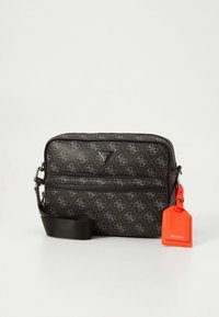 Borsa a tracolla nera con motivo a fantasia, texture liscia, logo grigio, tracolla e dettagli con tag per bagagli arancione.