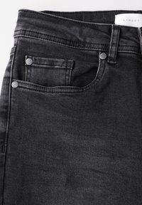 Pantalones vaqueros de mezclilla negra con un diseño clásico de cinco bolsillos, que cuentan con herrajes plateados, una superficie texturizada y un ligero desvanecimiento en la tela.