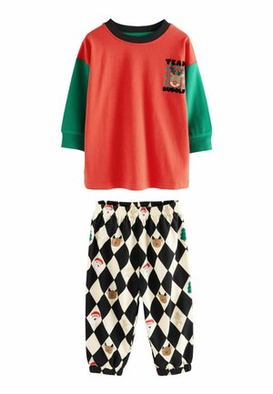 Rotes und grünes Langarmhemd mit Rentier-Grafik; schwarz-weiße karierte Hose mit Feiertagsmotiven wie Santa und Weihnachtsbäumen.
