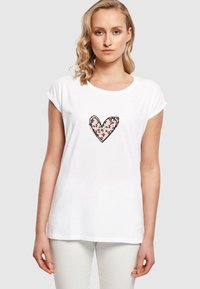 Hvid bomulds t-shirt med rund hals og korte rullede ærmer, med et rosa leopardmønster hjerte designet på fronten.