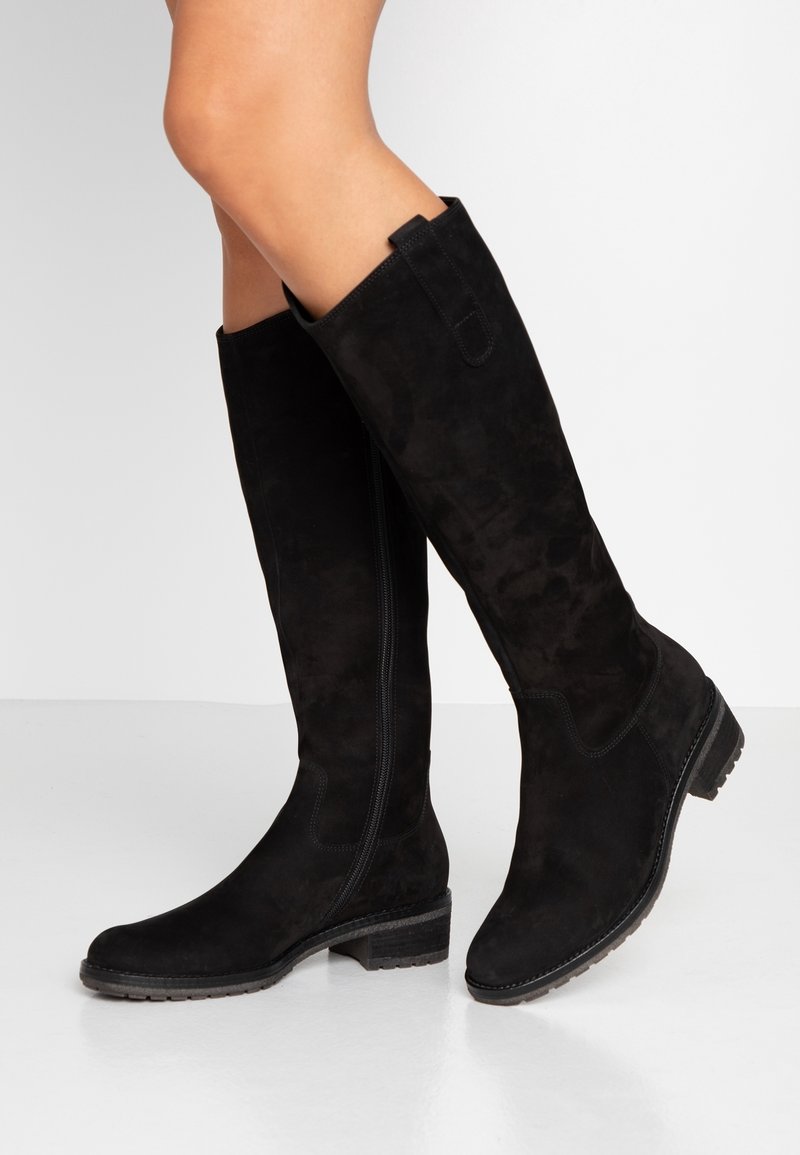Bottes noires en suède montant jusqu'aux genoux, avec un talon bloc, une fermeture éclair latérale et une languette de maintien. La texture est lisse, présentant un motif subtil à la surface.