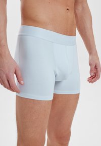 Ljusblå boxerkalsonger i mjuk bomull, med ett strukturerat midjeband med prägling och en åtsittande passform.