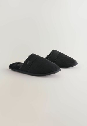 Sorte slippers lavet af blødt tilbageslagsmateriale med en luksuriøs indvendig, spids tå og minimalistisk design.
