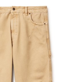 Pantalon de travail beige présentant une poche avant, une petite poche pour pièces, une passante de ceinture, une fermeture bouton et des coutures renforcées sur un tissu résistant.
