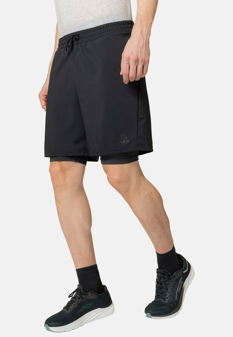 Schwarze Sportshorts mit elastischem Bund und Kordelzug. Enthält ein dunkelgraues Innenfutter. Logo auf der linken Vorderseite sichtbar.