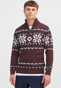 Maglione lavorato a maglia bordeaux con motivo di fiocchi di neve bianchi e teal, colletto con zip, polsini e orlo a costine, materiale in misto lana texturizzato.