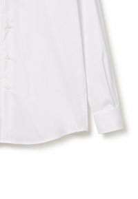 Camisa blanca de manga larga hecha de algodón suave, con cierre de botones en la parte delantera, dobladillo recto y puños con un botón.