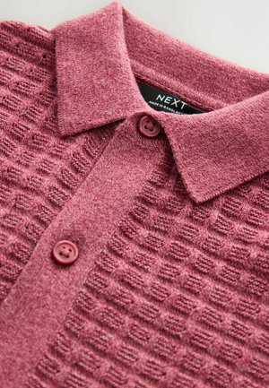 Bordeaux polo paita, jossa on nappikaulus, kudottu neliökuvio ja kaksi yhteensopivaa nappia kaulan kohdalla.