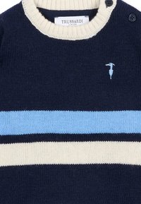 Granatowy sweter wełniany z kremowym kołnierzem i trzema poziomymi paskami w jasnoniebieskim, kremowym i granatowym kolorze. Zawiera mały detal z logo na klatce piersiowej.