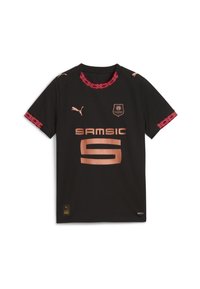 Melna futbola kreklu ar īsām piedurknēm, sarkanu dekoratīvu apdari, vara logotipu un uzrakstu "SAM SIC" ar lielu "9" centrā priekšpusē.