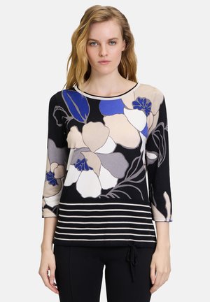Blusenshirt mit floralem Muster und Dreiviertelärmeln in Schwarz, Beige und Blau, mit horizontalen Streifen am Saum und rundem Halsausschnitt. Aus weichem Stoff hergestellt.
