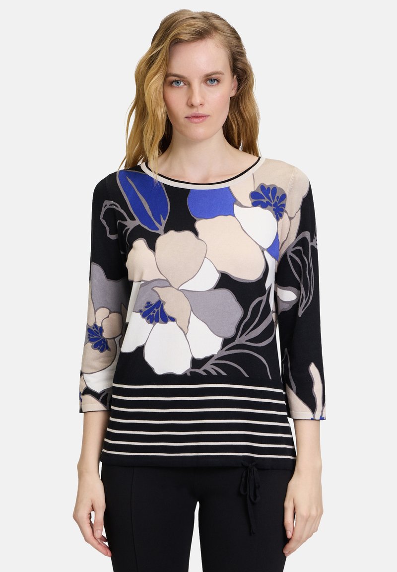 Blusenshirt mit floralem Muster und Dreiviertelärmeln in Schwarz, Beige und Blau, mit horizontalen Streifen am Saum und rundem Halsausschnitt. Aus weichem Stoff hergestellt.