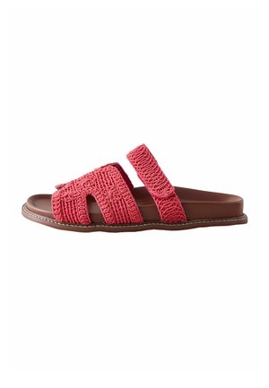 Sandale plate marron avec deux lanières texturées rose corail, une large lanière avant avec des découpes et une lanière réglable à la cheville.