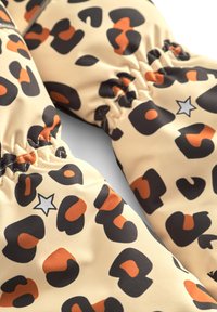 Guantes impresos que presentan una tela beige con manchas de leopardo en negro y naranja, fruncidos en la muñeca, adornados con una pequeña estrella gris.