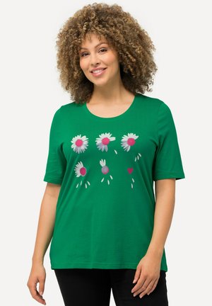 T-shirt verde a maniche corte in cotone, con stampa floreale di margherite e cuori in rosa e bianco nella parte anteriore.