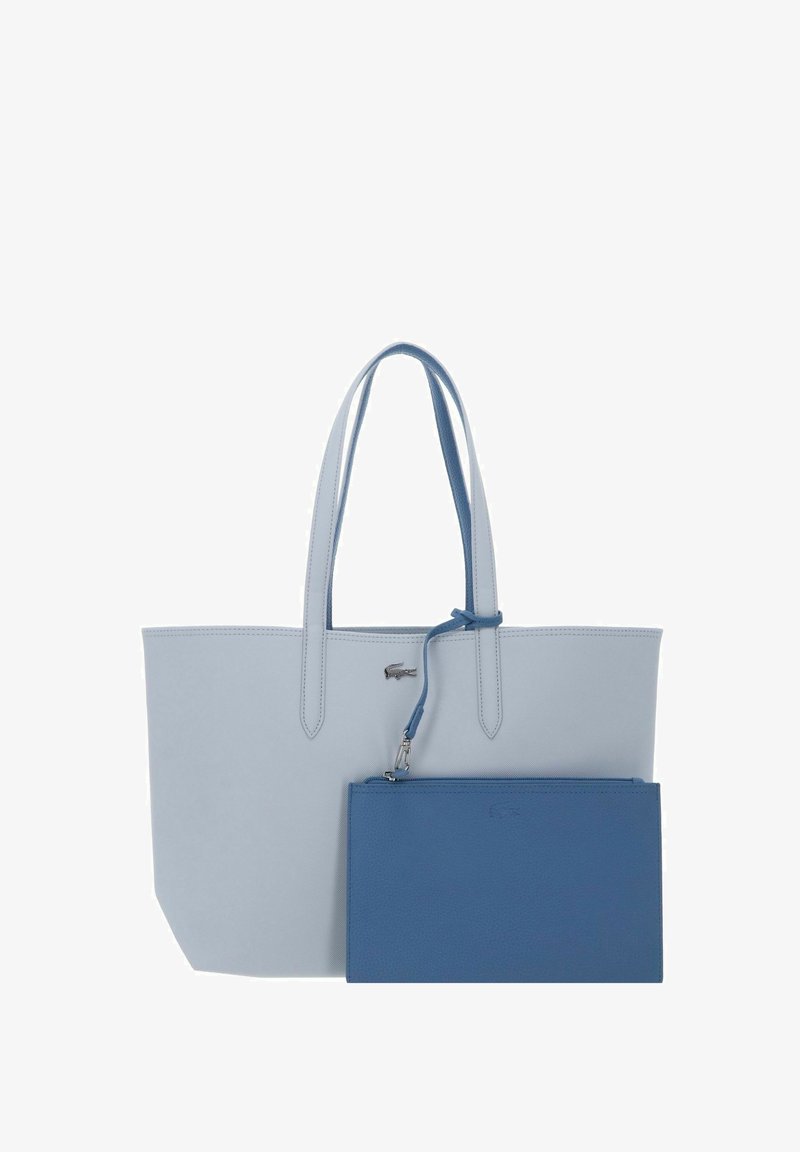 Hellblauer Tragetasche mit doppelten Griffen und einer vorderen, kleineren abnehmbaren blauen Tasche, beide aus strukturiertem Material gefertigt.