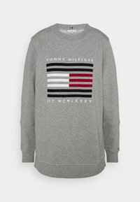 Sudadera gris de mezcla de algodón con un diseño gráfico que presenta rayas horizontales en negro, blanco y rojo. Incluye puños y dobladillo acanalados.
