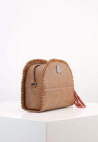 Hnědá kožená crossbody taška se šitím podél okrajů, obdélníkového tvaru, se zipovým uzávěrem a detailním třásněm na jedné straně.