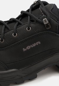 Schwarzer Wanderschuh aus glattem und strukturiertem Leder, mit Schnürsenkeln, Metallösen und einer gemusterten Gummisohle. "Lowa"-Logo sichtbar.