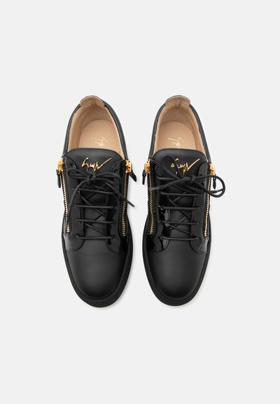 Μαύρα sneakers χαμηλού ύψους με χρυσά πλαϊνά φερμουάρ, μαύρα κορδόνια και μπεζ εσωτερική επένδυση, απεικονιζόμενα από πάνω προς τα κάτω.