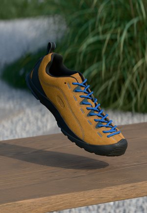 Orange suede sneaker with blue laces and black rubber sole. Features a pull tab at the heel and stitched detailing along the sides.