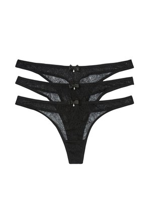String in pizzo nero, in tre paia con motivi floreali, cinture sottili, piccoli dettagli a fiocco e un pendente sul retro.
