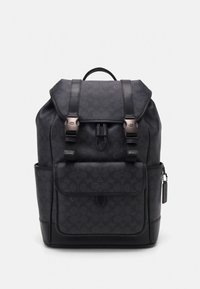 Svart ryggsäck med strukturerad yta, dubbla remmar, metallbeslag, stor främre ficka och accessoartagg. Har ett minimalistiskt logomönster.