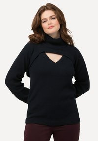 Dunkelblaue Strickjacke mit einem hohen Kragen und einem breiten, ausgeschnittenen V-Ausschnitt in der Brustmitte. Strukturiertes Gewebe mit gerippten Akzenten an den Ärmelbündchen und am Saum.