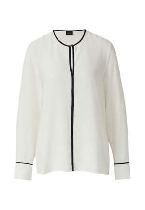 Chemisier blanc à manches longues avec un col rond, des bordures noires et une patte de boutonnage sans boutons. Tissu lisse avec des manches à boutons.
