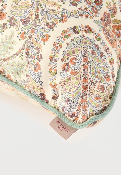 Coussin décoratif avec un motif cachemire floral complexe orange, vert et marron, bordure tressée verte et étiquette en tissu portant la mention "ETRO HOME"