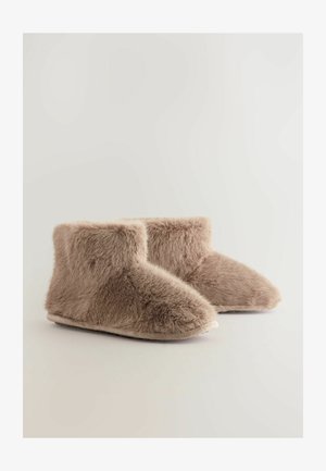 Zapatillas de casa de faux fur marrón suave, con un eje corto y redondeado y una forma de punta curva; con una textura mullida y una suela plana y antideslizante.