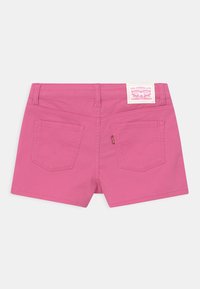 Rosa bomullsshorts med hög midja, två bakfickor och en etikettpatch på midjebandet. Har böjda sömmar och en slät yta.